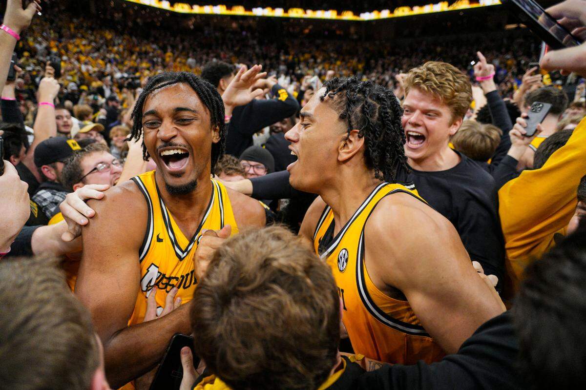 Missouri Tigers guards Aidan Shaw (23) and Trent Pierce (11) celebrate with fans after defeating the Kansas Jayhawks at Mizzou Arena on Dec. 8, 2024.