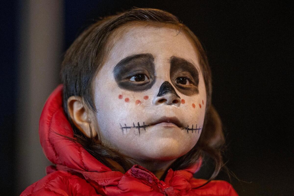 Two-year-old Esteban Arellano, watches the Dia de los Muertos festival parade at the Mattie Rhodes Center.
