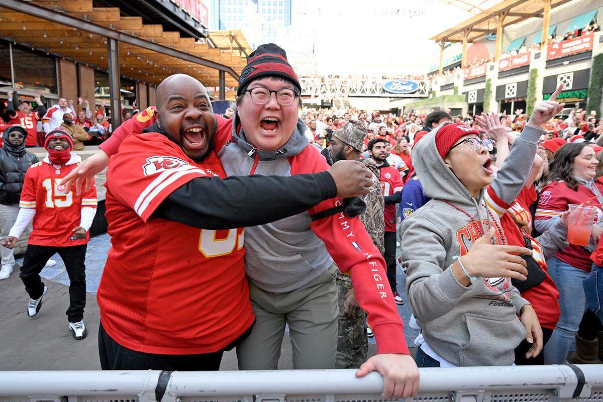 Chiefs fans from left,&nbsp;Jimmie Clark of East St. Louis, Andrew Kang of Kansas City , and his brother, Joonyoung Yang, right, who flew in from South Korea Sunday for the Chiefs game with his brother, celebrate a touchdown at the Power & Light District to watch the AFC Championship game between Kansas City and Baltimore on Sunday, Jan. 27, 2024, in Kansas City. 