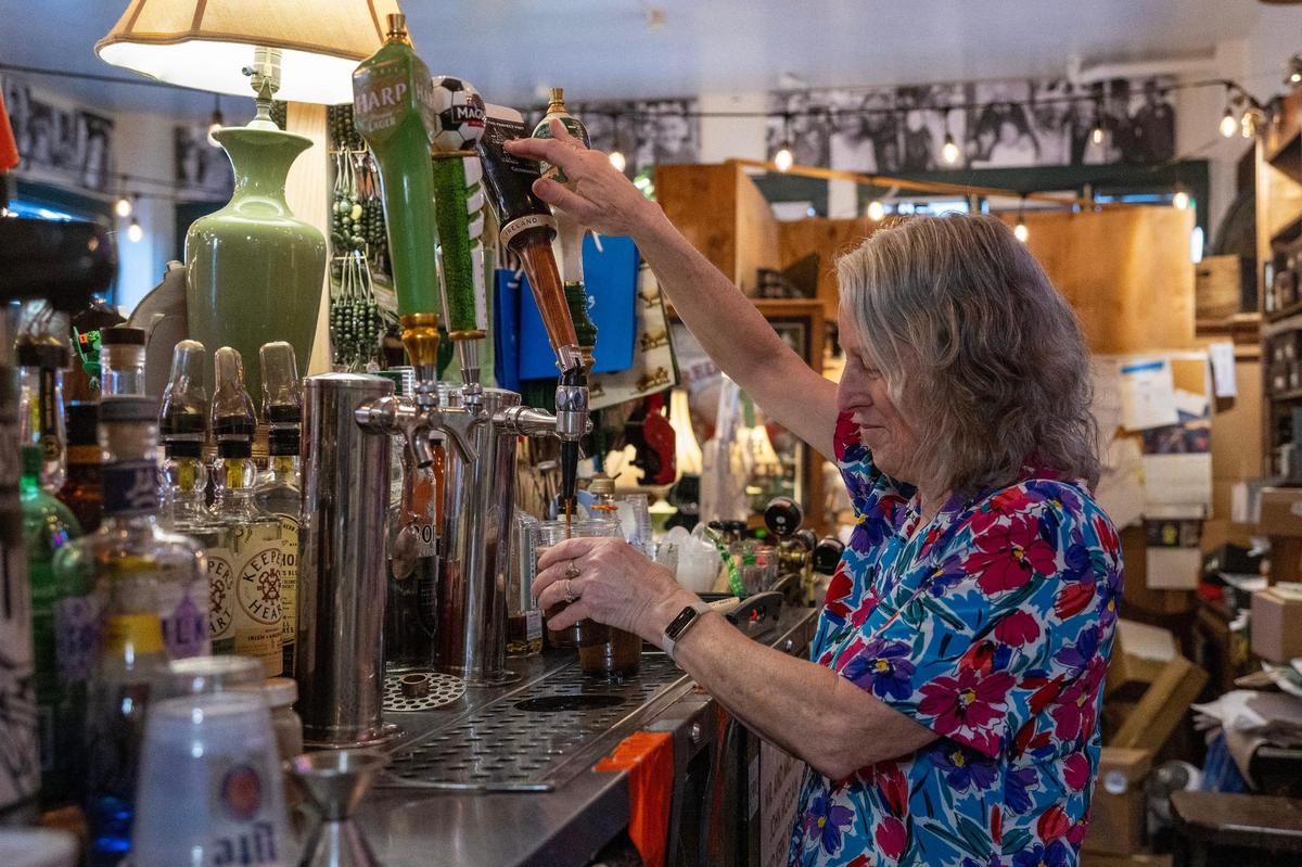 Kathleen Stark pours a pint of Guinness for a guest at Browne’s Irish Marketplace.