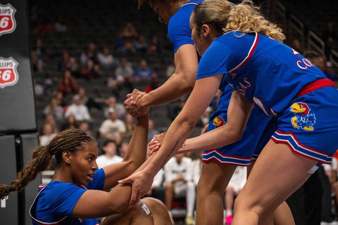 Kansas Jayhawks guard S'Mya Nichols (12) is picked up by teammates following a foul in the first half of KU’s second-round game at the Big 12 Women's Basketball Tournament on Thursday, March 5, 2026, at T-Mobile Center in Kansas City.