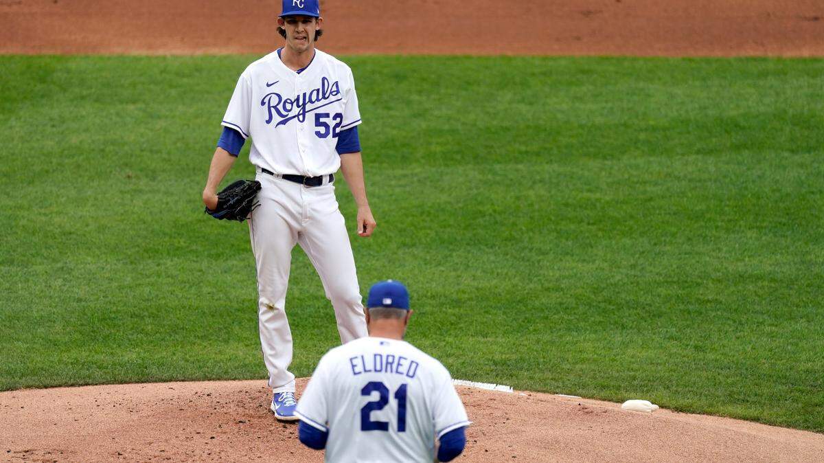 Kansas City Royals starting pitcher Daniel Lynch waits on the mound for a visit from pitching coach Cal Eldred during the first inning of a baseball game against the against the Chicago White Sox Saturday, May 8, 2021, in Kansas City, Mo. (AP Photo/Charlie Riedel)