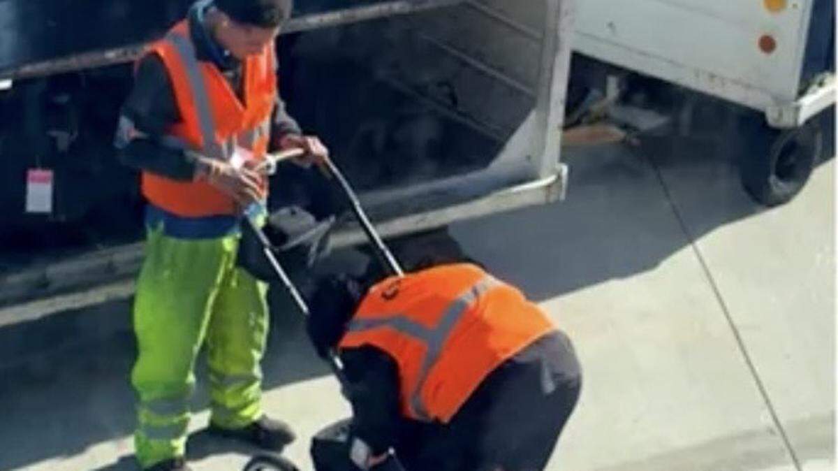 Two baggage handlers at Kansas City International Airport have gone viral after passengers watched them struggle to collapse a baby stroller.
