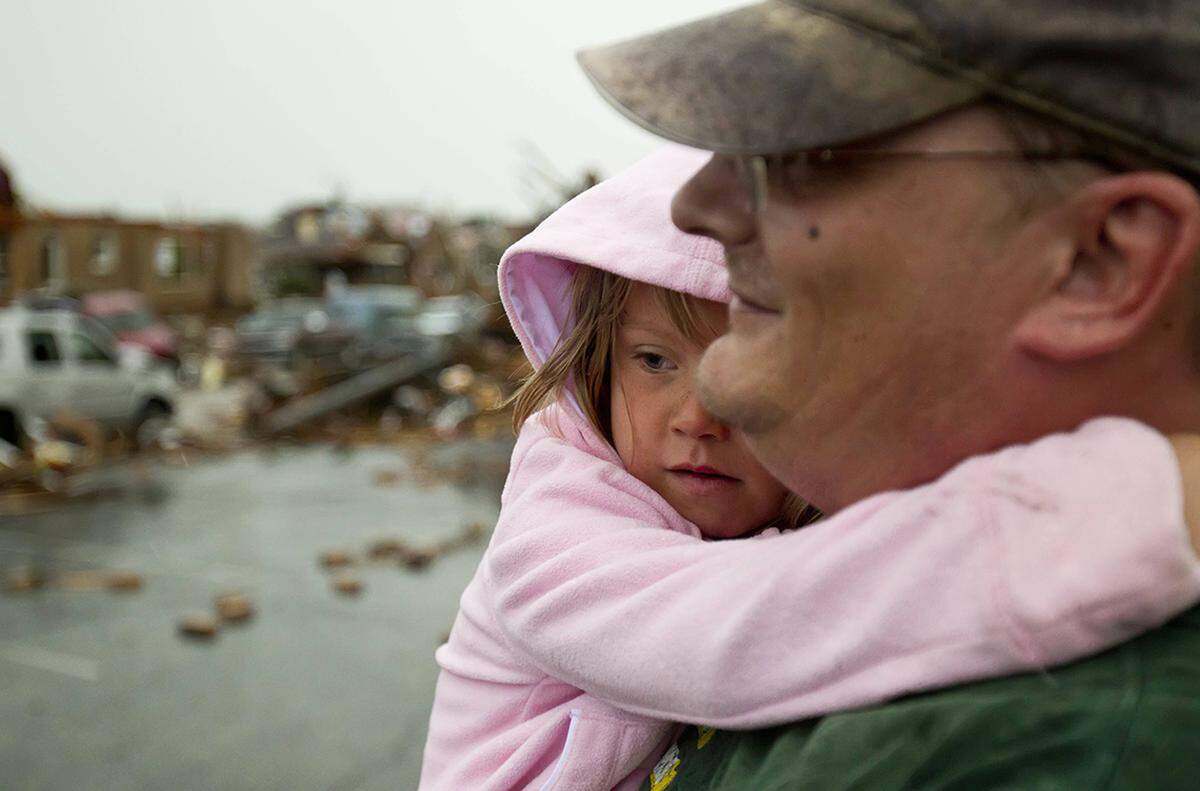 Dallas Lee, 6, held onto family friend Scott Rowan’s neck as the pair searched for salvageable items from the truck Dallas was in during the tornado.