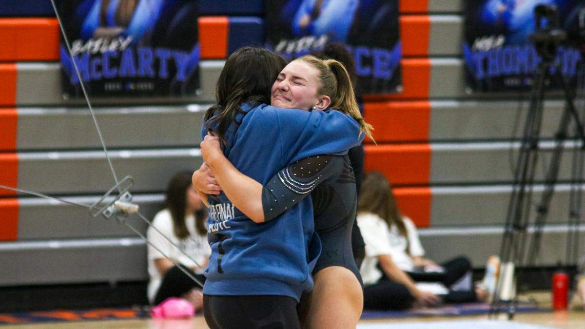Harper Huston, a freshman of Lawrence Free State High School, hugs her coach Alexis Gonzales after competing in the state championship meet on Oct. 25, 2025.