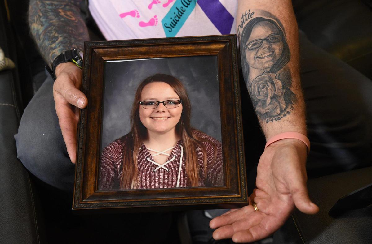 Ralph Garrigus of Warsaw, Missouri, displays a photo of his beloved daughter Riley and the tattoo he got to memorialize her. Riley, then 16, had been relentlessly bullied in school and took her life with her father’s gun at the family’s home in Sedalia, Missouri, in April 2017.
