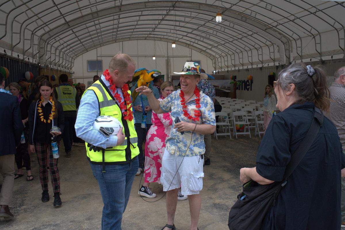 Clifton Bencke, right, shows off a parrot named Captain Flint during a ceremony on Wednesday, May 8, 2024, at the site of the under-construction Margaritaville Hotel in western Kansas City, Kansas.
