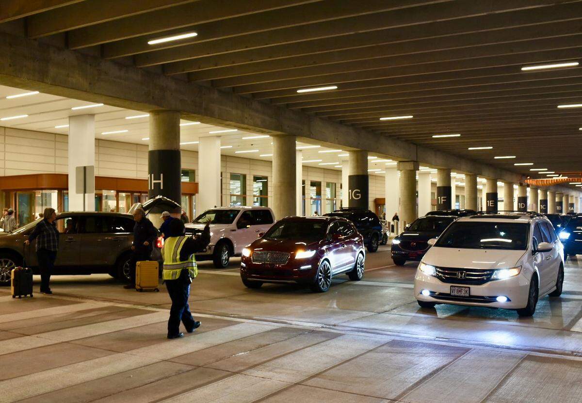 Traffic control officers at Kansas City International Airport’s new terminal try to keep traffic moving. People have been experiencing long delays caused by drivers parking and waiting for travelers at the curb like they did at the old terminals.