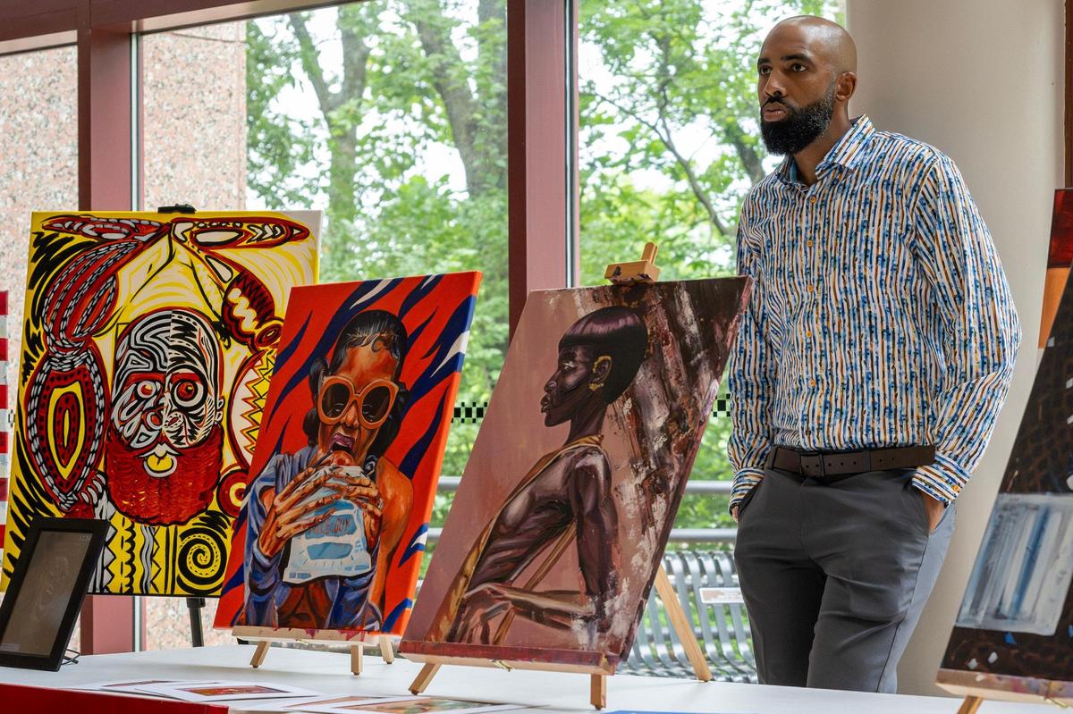 Artist Isaiah Russell stands alongside his work while its on display at the Bruce R. Watkins Cultural Center during KC Hip-Hop Week in Kansas City on Thursday, June 5, 2025.