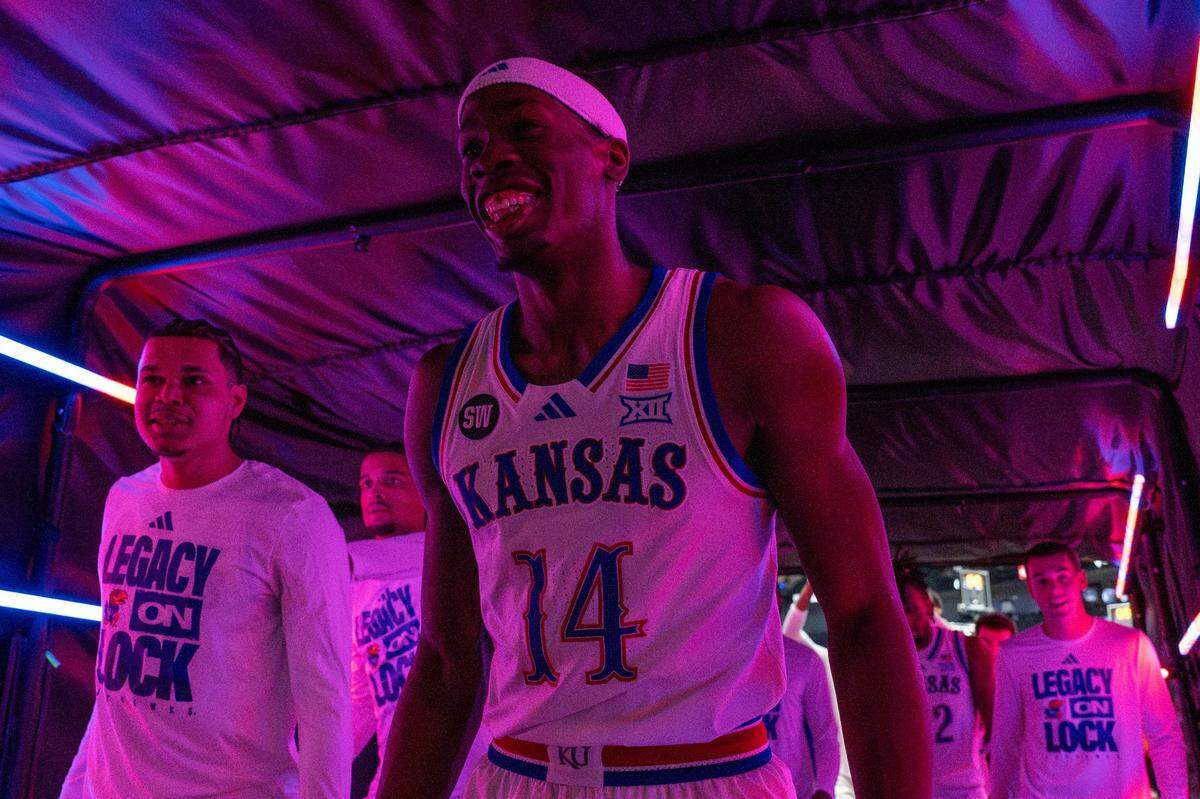 Kansas guard Melvin Council Jr. (14) smiles while walking down a dimly lit tunnel after Kansas defeated TCU 78-73 in a Big 12 Men's Basketball Tournament game at T-Mobile Center on Thursday, March 12, 2026, in Kansas City.