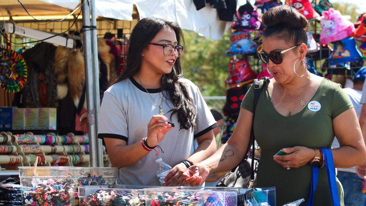 People attending Fiesta Hispana look at souvenirs at a vendor booth on Sept. 13, 2025.