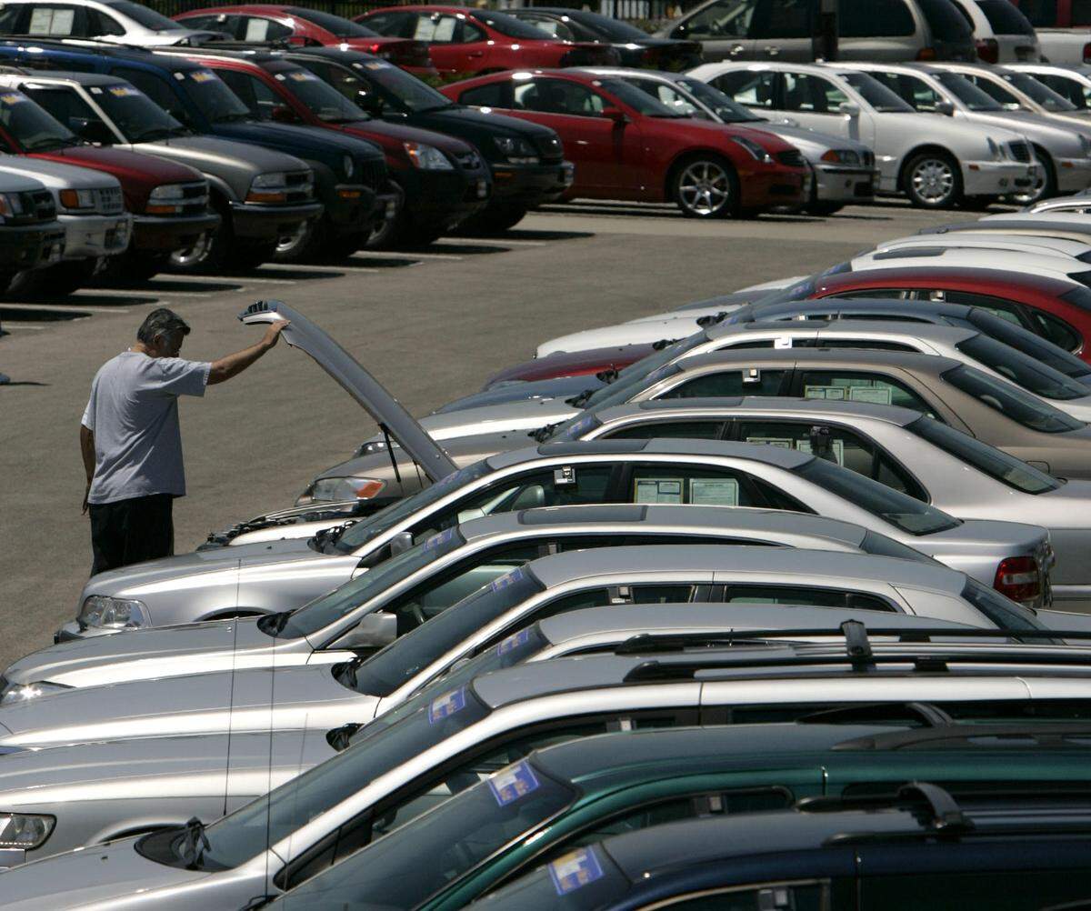 Joe Marquez, of Shawnee, Kansas, looks under the hood as he shops for a used car at the Carmax lot in Merriam, Kansas, in this 2005 AP file photo.