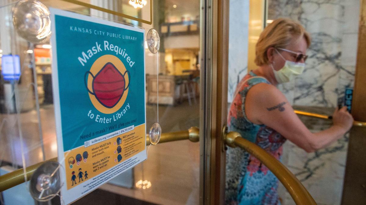 Carolyn Molloy walks out the Central branch of Kansas City Public Library with a bag of books on Thursday afternoon, July 29, 2021 in Kansas City. Molloy, a healthcare professional, is glad that the library was reopened in June after a year-long shutdown. She said she is sad to see another round of mask mandate due to low vaccination rate.
