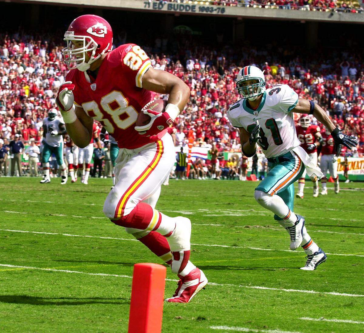 Kansas City Chiefs tight end Tony Gonzalez (88) heads for a touchdown in front of Miami Dolphins safety Brock Marion (31) in the third quarter on Sept. 29, 2002, at Arrowhead Stadium.