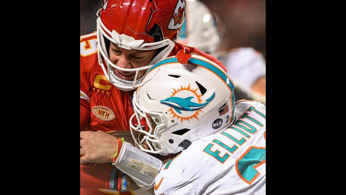 The helmet of Kansas City Chiefs quarterback Patrick Mahomes (15) breaks while being hit by Miami Dolphins safety DeShon Elliott (21) on a run in the third quarter Saturday, Jan. 13, 2024, at GEHA Field at Arrowhead Stadium.