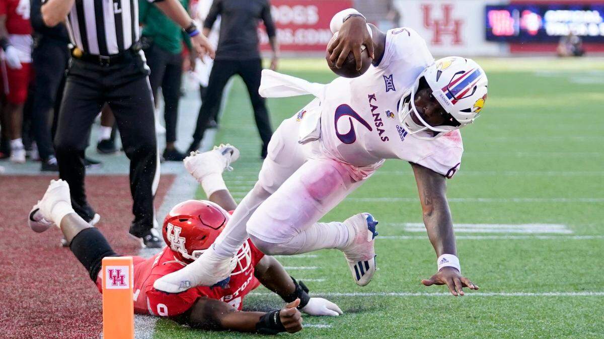 Kansas quarterback Jalon Daniels leaps into the end zone for a touchdown, one of the five he scored Saturday against the Houston Cougars at TDECU Stadium in Houston.