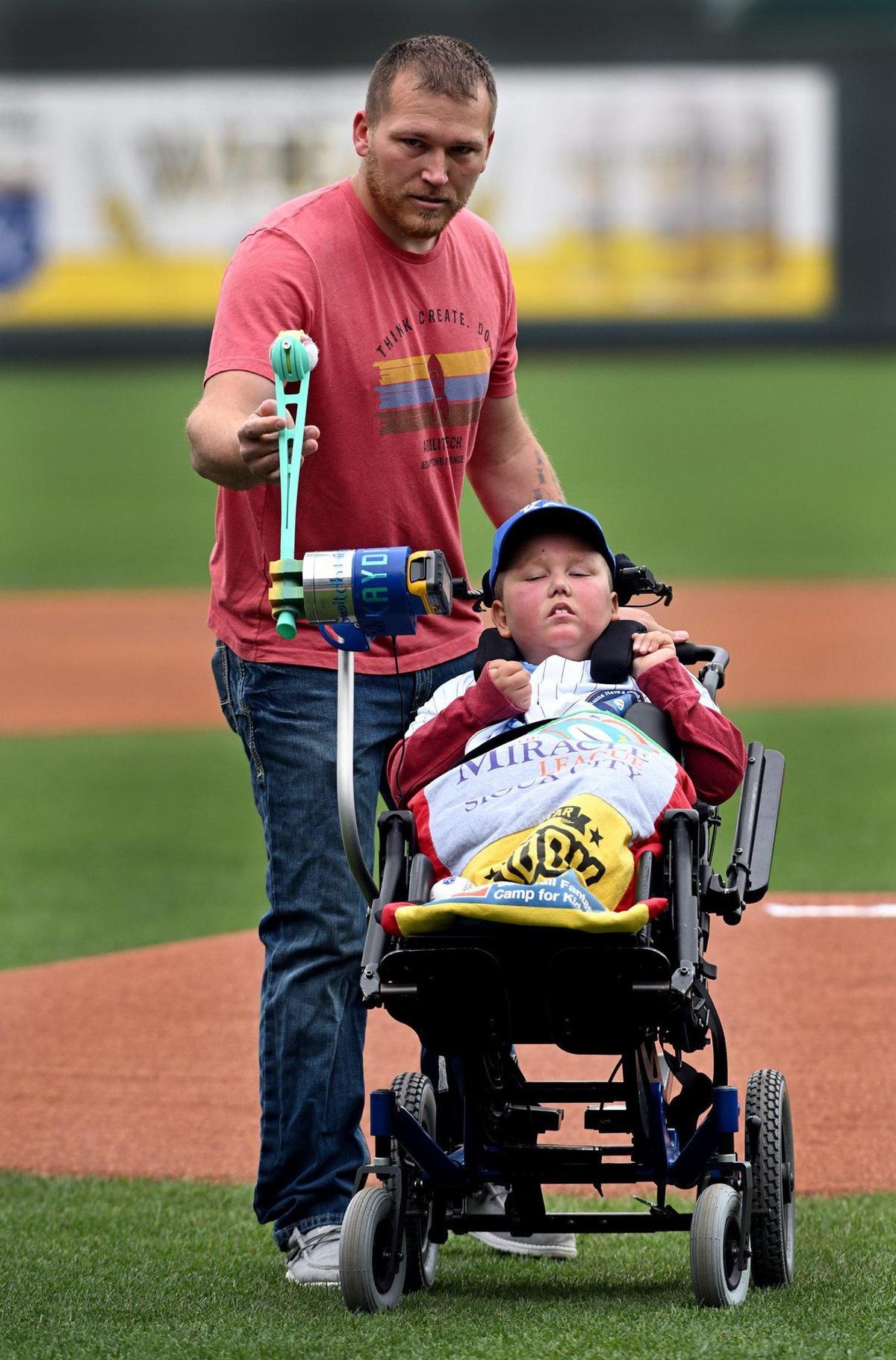 Kayden Rhoades was given 24 hours to live at birth, but 15 years later he threw out the first pitch on Thursday at Kauffman Stadium with the help of his family. Rhoades, who was born with hydranencephaly, used a device his father Dustin created for him to complete the feat. It was a bucket list day in every way for the family from Sioux City, Iowa.