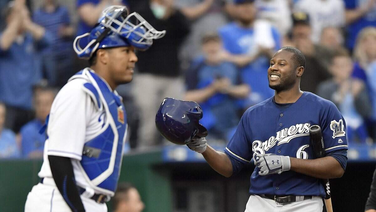 The Brewers' Lorenzo Cain tipped his helmet to the cheering crowd in front of catcher Salvador Perez before taking his first at-bat in Tuesday's game at Kauffman Stadium.