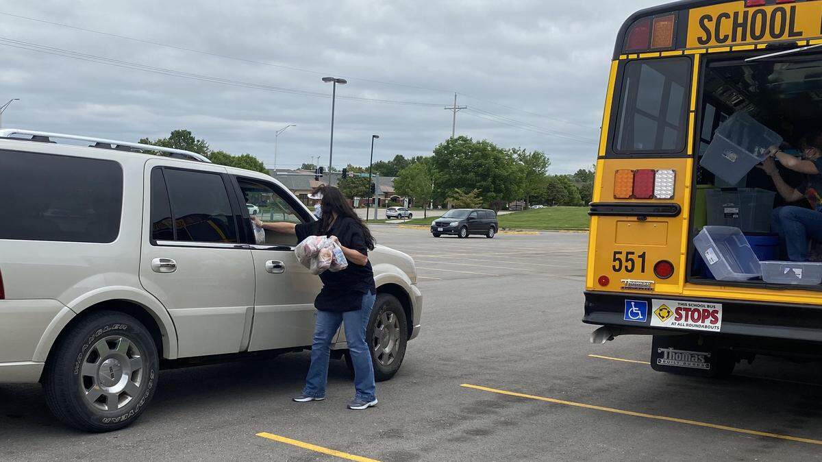 Missy Hanner, cafeteria manager at Lee’s Summit North, hands out packed lunches and breakfasts to families as part of the district’s emergency feeding plan