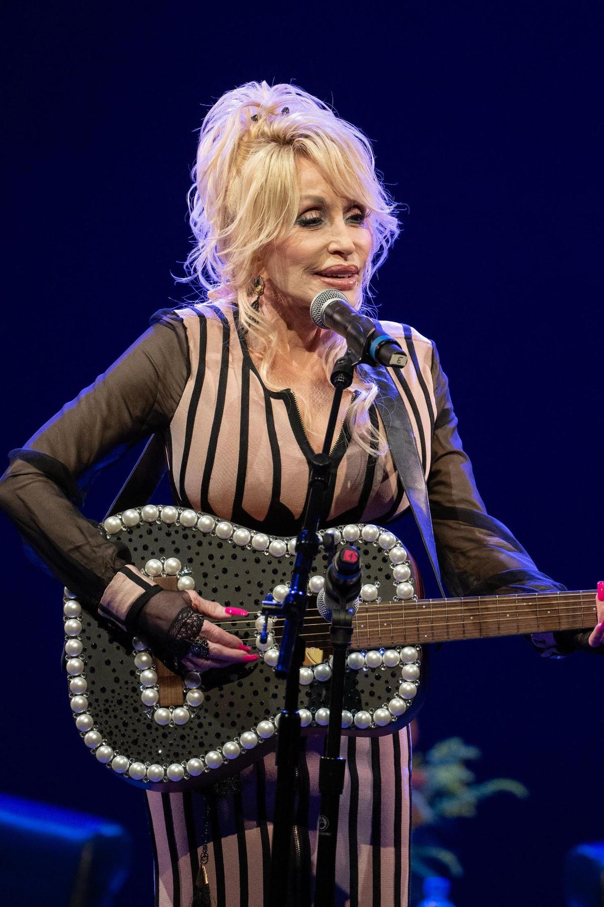 Dolly Parton performs the song “Coat of Many Colors” during an event celebrating the full implementation of the Imagination Library at White Theatre at the Jewish Community Center on Monday, Aug. 14, 2023, in Overland Park, Kan.