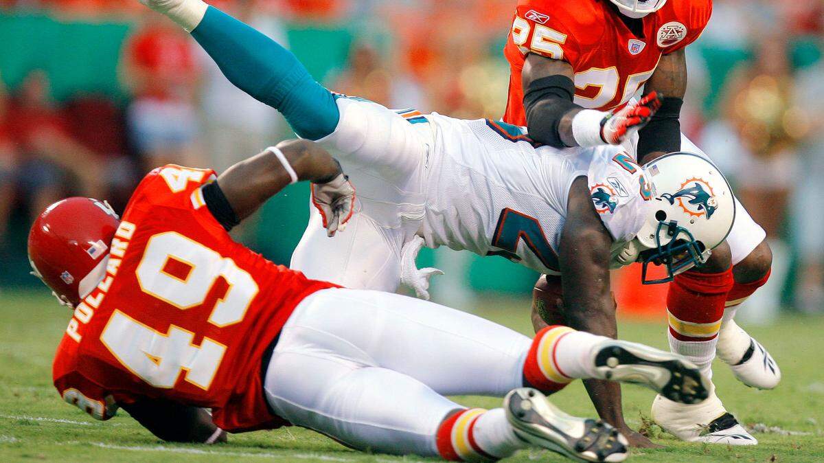 David Eulitt/The Kansas City Star 8/16/2007 (SPORTS) Kansas City Chiefs safety Bernard Pollard trips off Miami Dolphins running back Ronnie Brown with 11:06 remaining in the first quarter during Thursday’s August 16, 2007, preseason football game between the Kansas City Chiefs and Miami Dolphins at Arrowhead Stadium in Kansas City, MO. cutline: Chiefs safety Bernard Pollard (left) tripped up Dolphins running back Ronnie Brown in the first quarter as fellow safety Greg Wesley came in to help. Before the game Thursday night, Dolphins quarterback Trent Green received a warm hug from his former coach, Herm Edwards.
