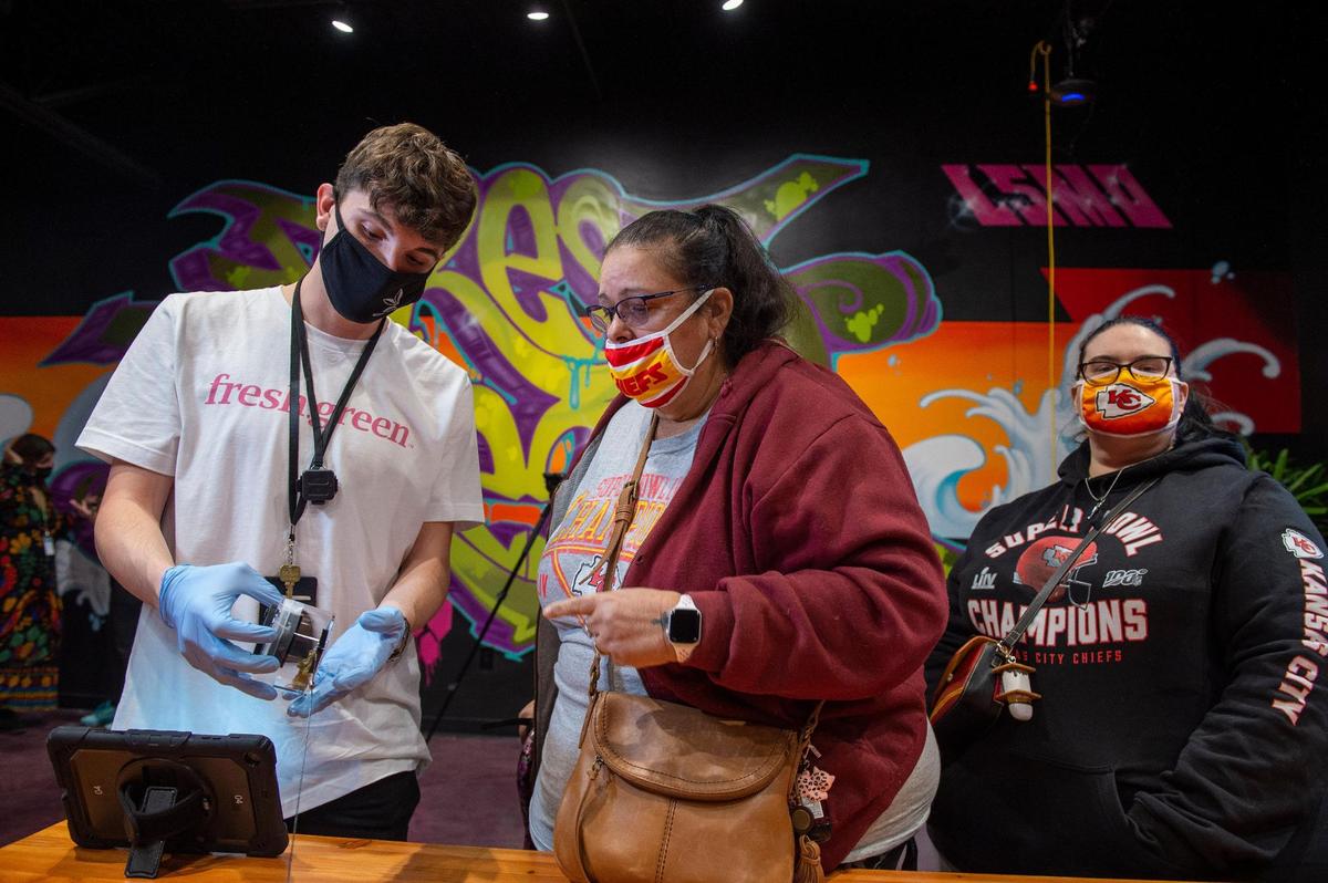 Robert Sullivan, left, displayed a container of marijuana to customer Brenda Dougherty at Fresh Green, a dispensary in Lee’s Summit, on the first day of medical sales. The dispensary will begin recreational sales on Friday.