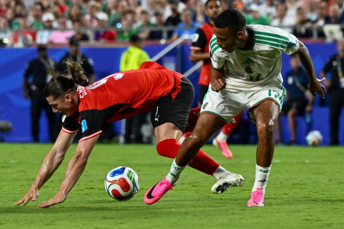Austria midfielder Marcel Sabitzer (9) makes a dive while being guarded by Algeria defender Rafik Belghali (17) during the World Cup game between Algeria and Austria at Kansas City (Arrowhead) Stadium on Saturday, June 27, 2026.