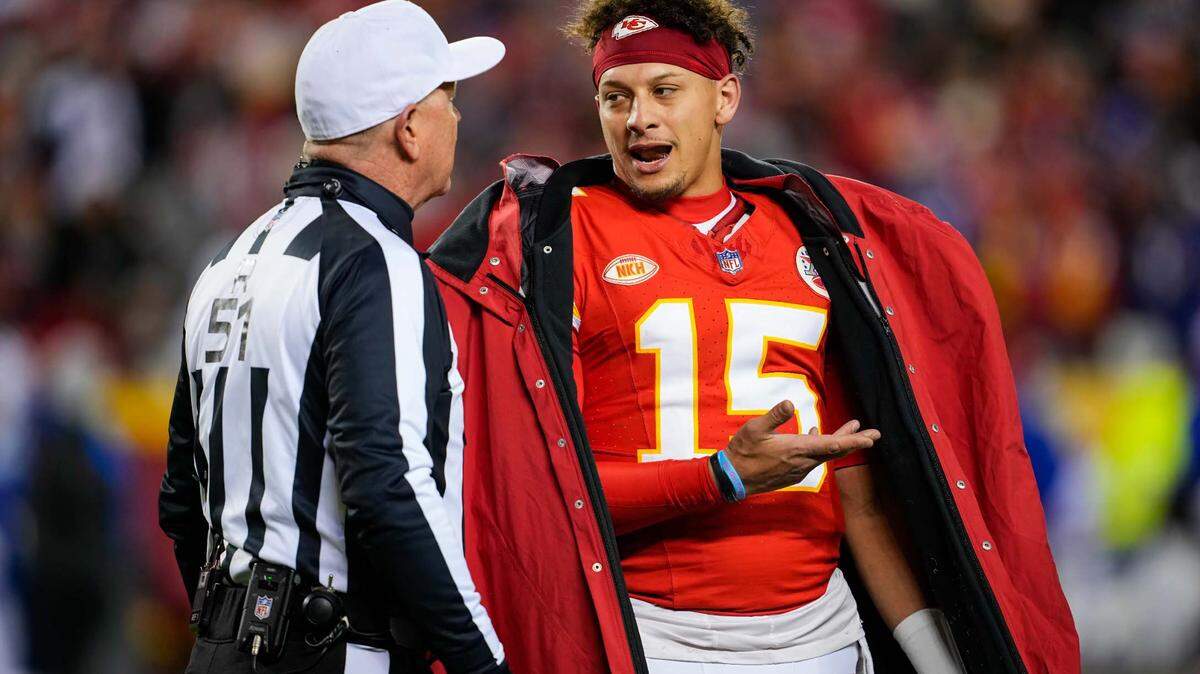 Kansas City Chiefs quarterback Patrick Mahomes (15) talks with referee Carl Cheffers (51) after penalty during the second half of a game against the Buffalo Bills at GEHA Field at Arrowhead Stadium.