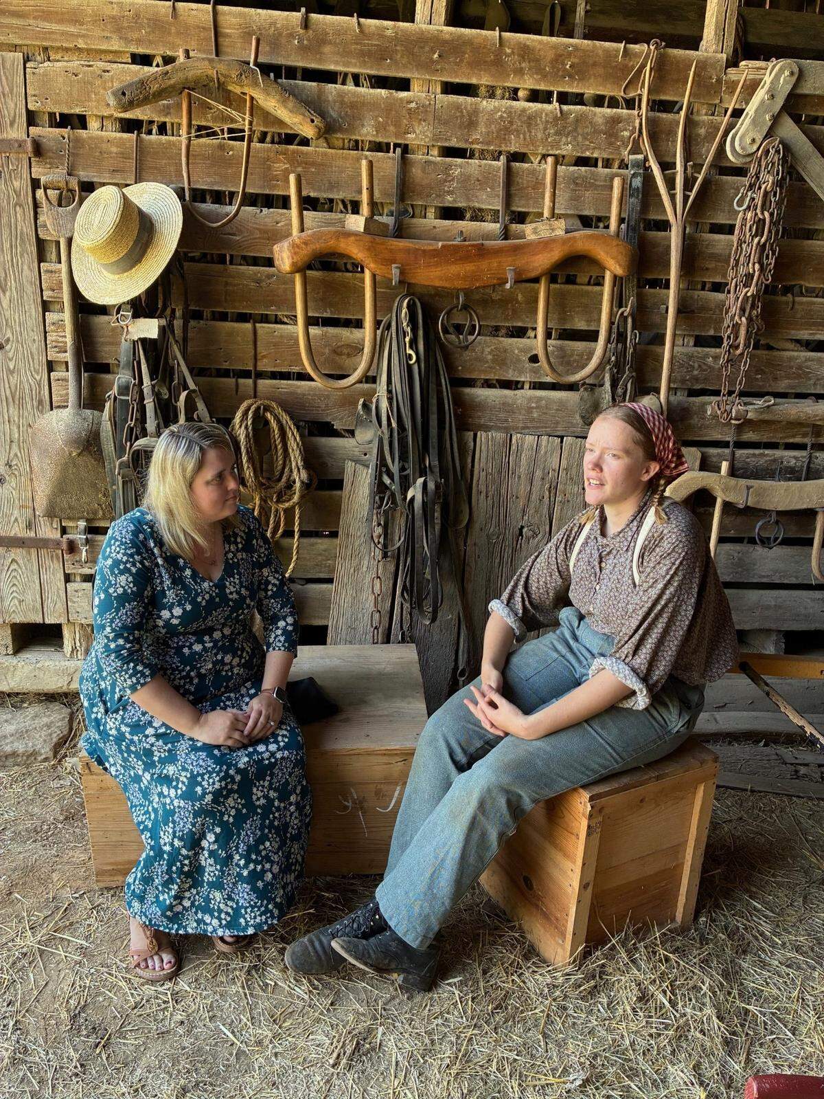 Dr. Amy Coale, site administrator at Missouri Town, and living history interpreter Maryn Edwards talk in the livery barn on July 1.