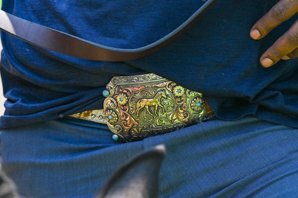 No stranger to cowboy fashion, Trae Q. L. Venerable sports a belt buckle featuring a horse.
