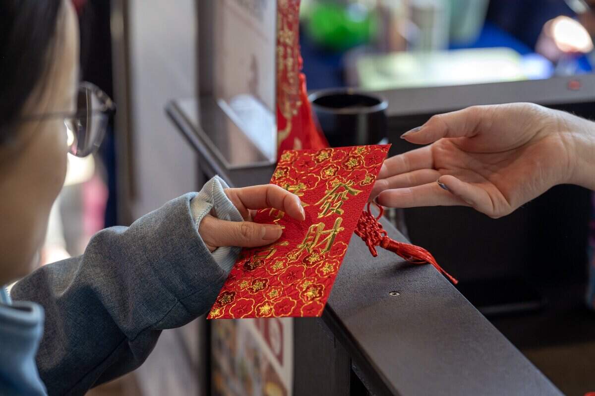 A guest receives a lucky red envelope during a Lunar New Year celebration at the Lenexa Public Market on Sunday, Feb. 22, 2026, in Lenexa.