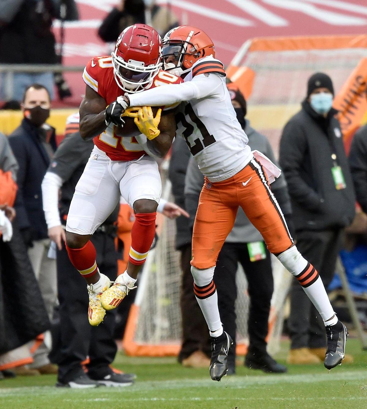 Kansas City Chiefs wide receiver Tyreek Hill makes a catch for a first down in the fourth quarter as Cleveland Browns cornerback Denzel Ward tries to break up the play. Cleveland challenged the play but it was upheld. The Chiefs defeated the Browns 22-17 in the AFC Divisional Playoff game at Arrowhead Stadium Sunday, Jan. 17, 2021.