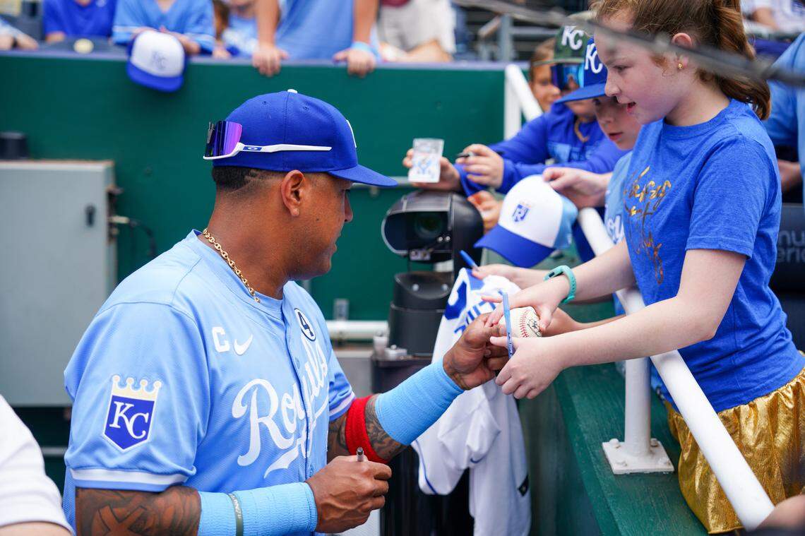 Kansas City Royals captain Salvador Perez (13) signs autographs for young fans prior to a game at Kauffman Stadium on June 2, 2024.