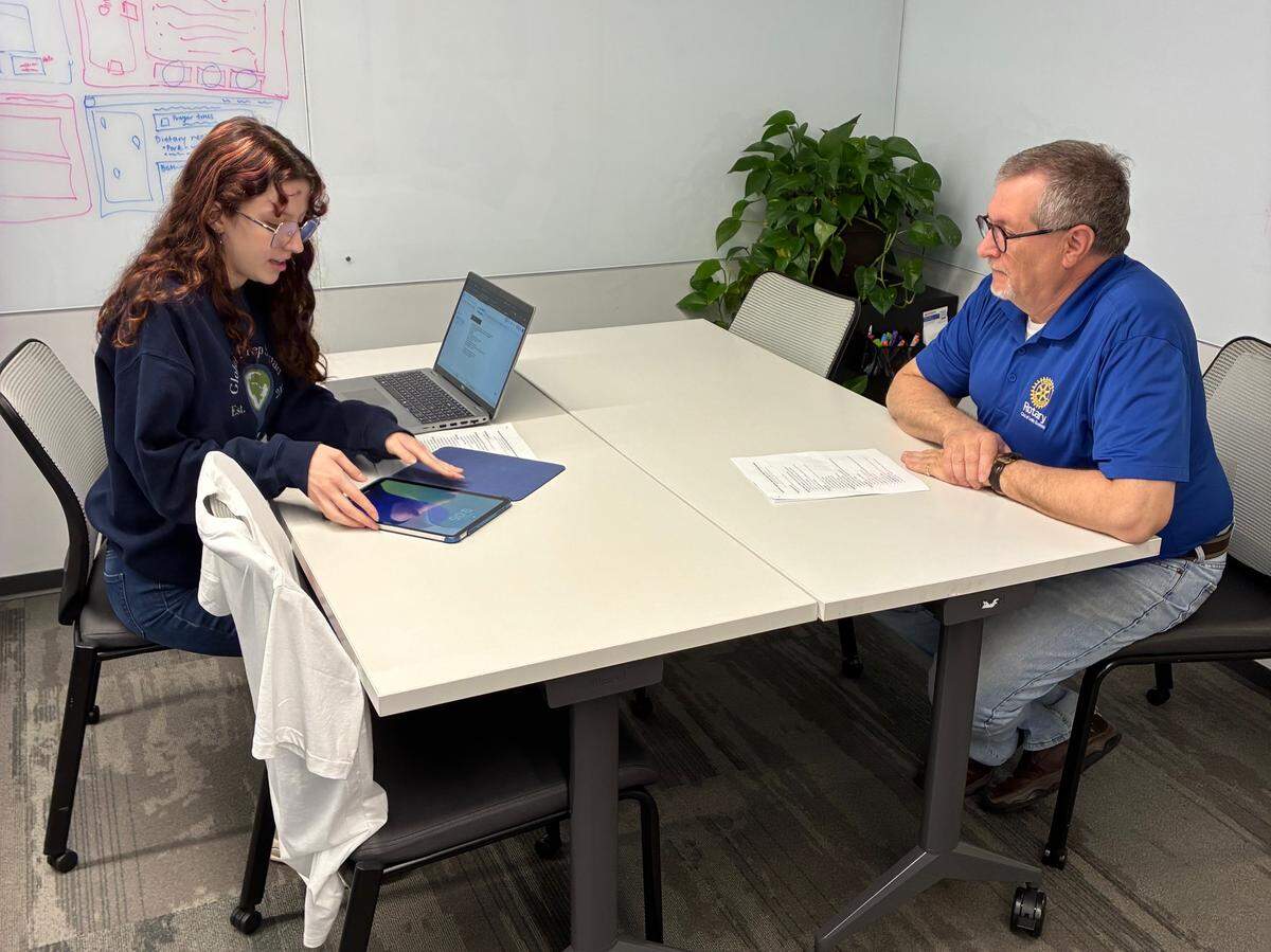 Grace Nurnberg, project manager for Host Ready, shares the app’s capabilities with Ben Martin of the Rotary Club.