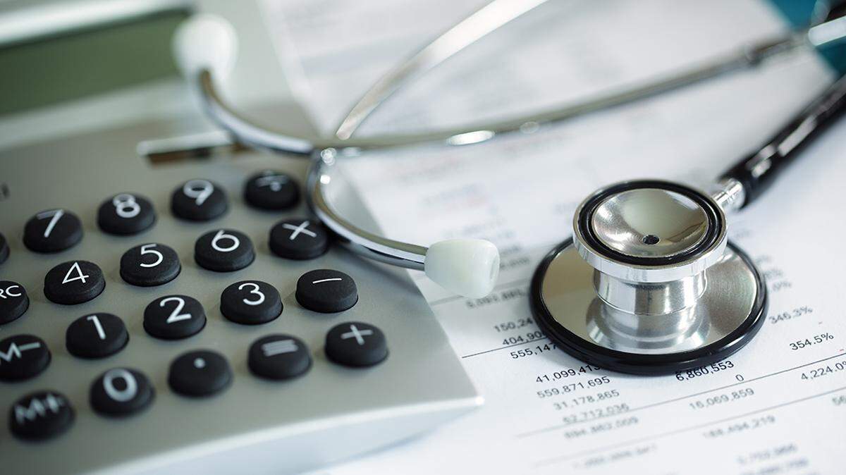 Calculator and stethoscope on financial statement concept for finance health check or cost of healthcare health care
