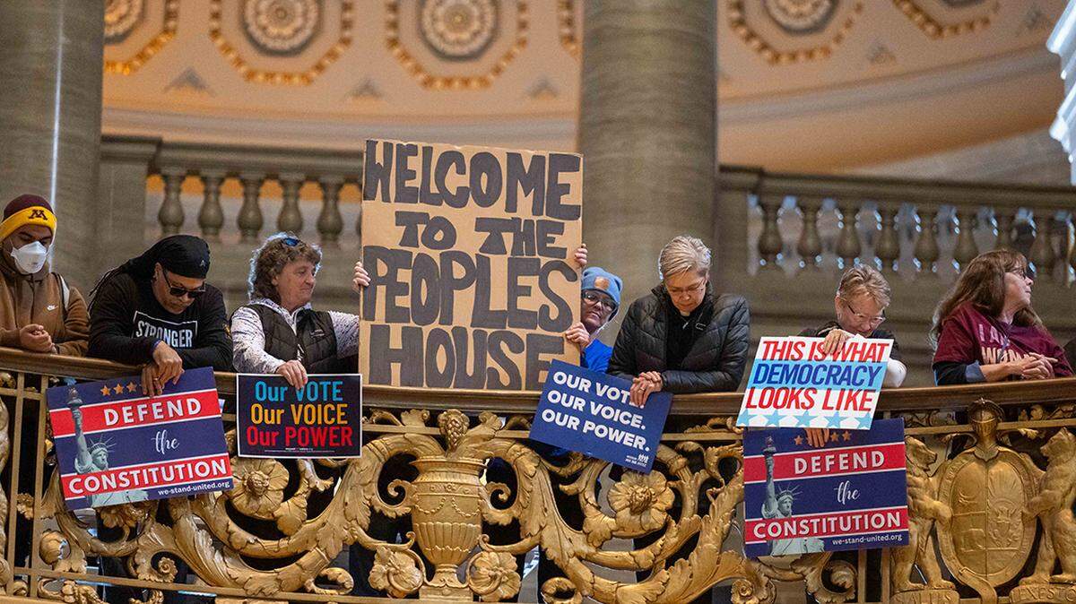 Protesters hold signs in the Missouri State Capitol rotunda on Jan. 21 in Jefferson City.