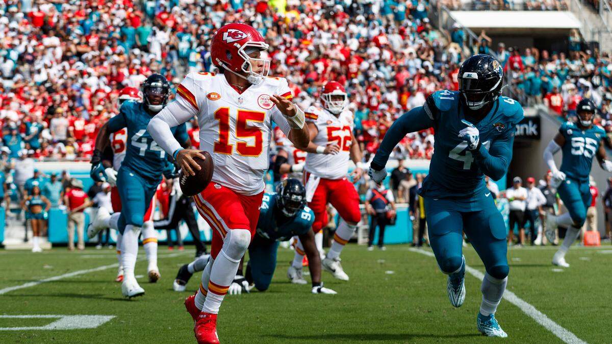 Kansas City Chiefs quarterback Patrick Mahomes (15) runs with the ball under pressure from Jacksonville Jaguars outside linebacker Josh Allen (41) during the third quarter at EverBank Stadium.