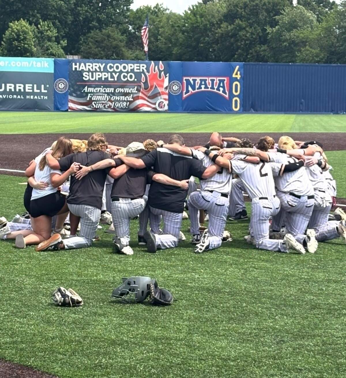 The Excelsior Springs baseball team huddled in prayer before the 2026 4A state title game against Orchard Farms.
