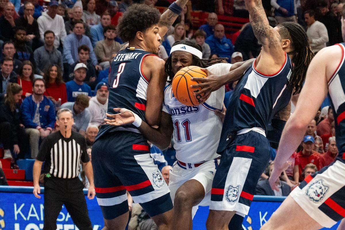 Kansas Jayhawks guard Jamari McDowell (11) drives into UConn Huskies defenders in the second half on Tuesday, December 2, 2025, at Allen Fieldhouse.