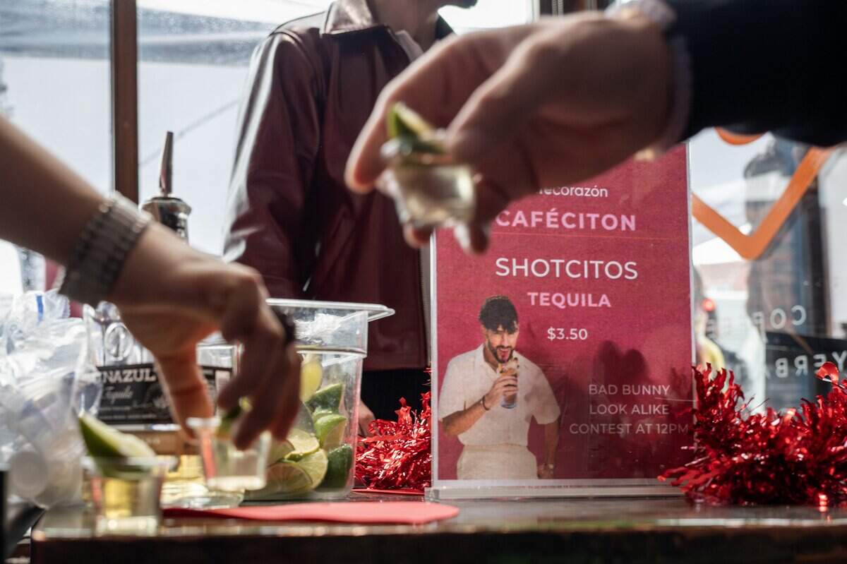 Attendees purchase tequila shots during the Bad Bunny look-alike contest at Café Corazón on Saturday, Feb. 14, 2026, in Kansas City.