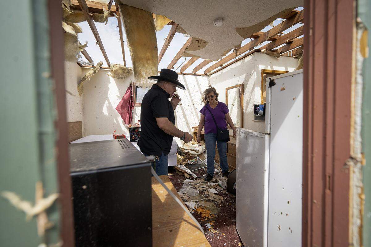 Ronald Hale of Liberty, Kansas, eats an ice cream sandwich from his son’s refrigerator as he and his wife, Jackie Hale, looked around the son’s residence at the Nevada Oaks apartment after a tornado hit the complex on Wednesday, April 2, 2025, in Nevada, Missouri. Hale’s son, Samuel Hale, 18, was uninjured. 