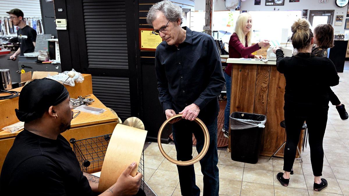 Wes Faulconer, middle, and his wife Lorene, at the counter, assist customers at Explorers Percussion. The couple plan to close their Waldo drum shop at the end of March.