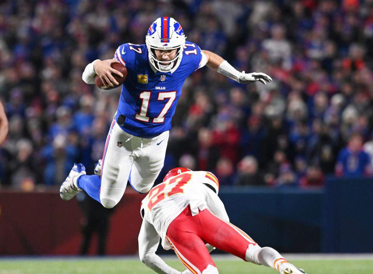 Buffalo Bills quarterback Josh Allen leaps over Kansas City Chiefs safety Chamarri Conner en route to a first down during a Week 11 NFL game at Highmark Stadium in Orchard Park, New York, on Sunday, Nov. 17, 2024.