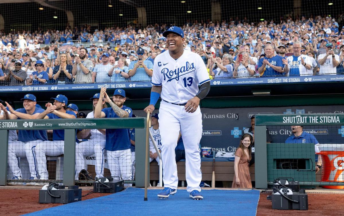 Kansas City Royals’ Salvador Perez laughs as he brings a cane to former Kansas City Royals center fielder Lorenzo Cain during a retirement ceremony at Kauffman Stadium on Saturday, May 6, 2023, in Kansas City. Cain signed a ceremonial one-day contract to retire as a Royal.