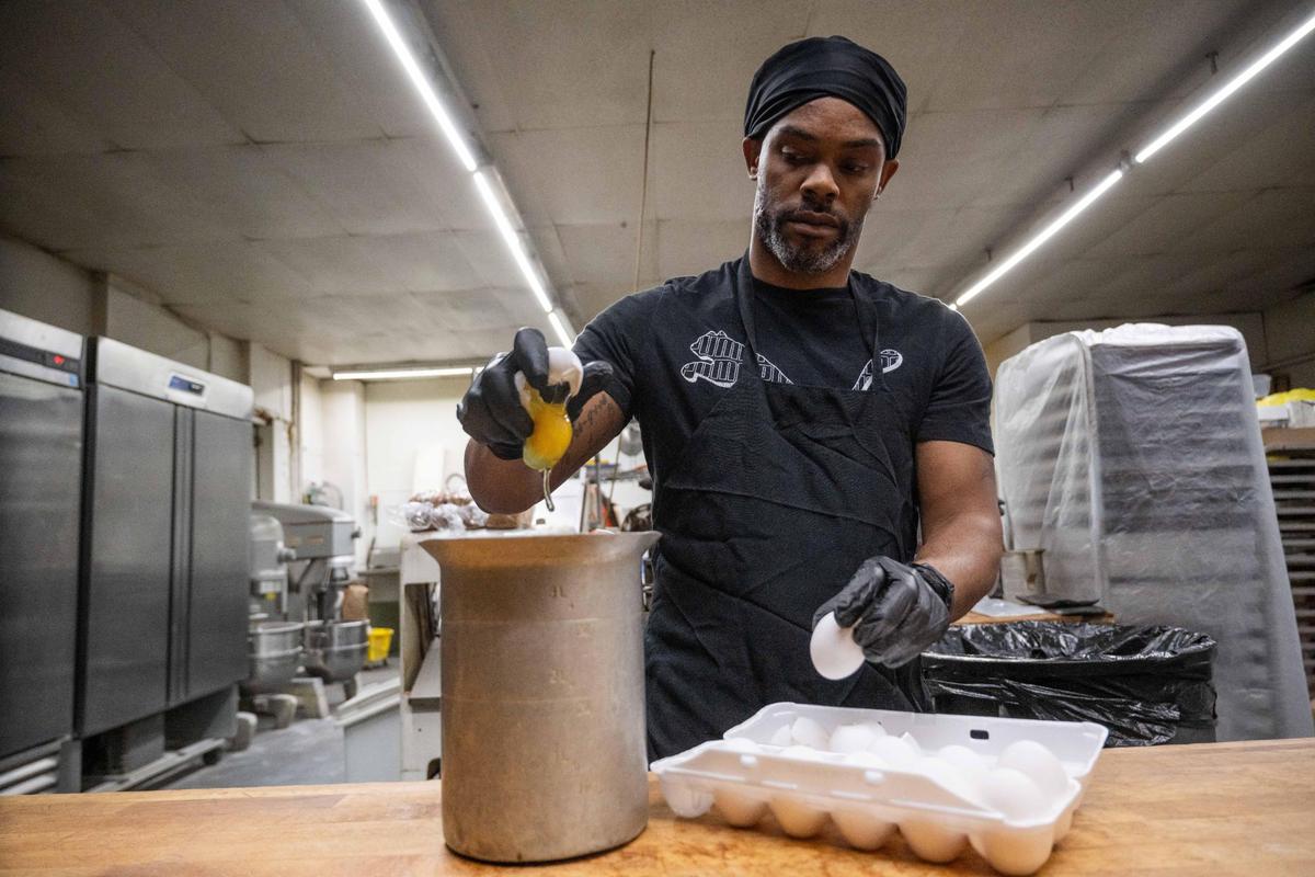 LaRon Williams, lead baker at M&M Bakery and Delicatessen cracks eggs for a dough on Wednesday at the Kansas City bakery.