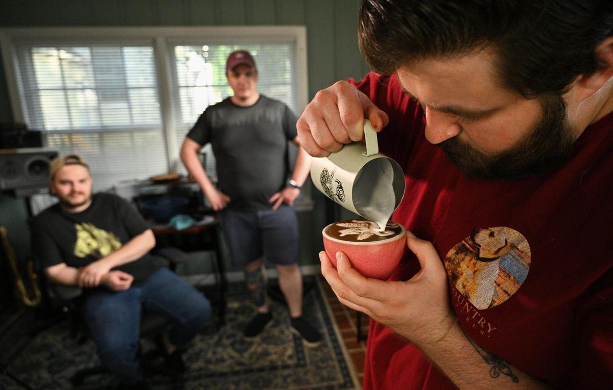 Edward Griffin, right, pours a pegasus design as fellow latte artists and baristas Jacob Kingsley, left, and Tristan Smith watch at Kingsley’s home.