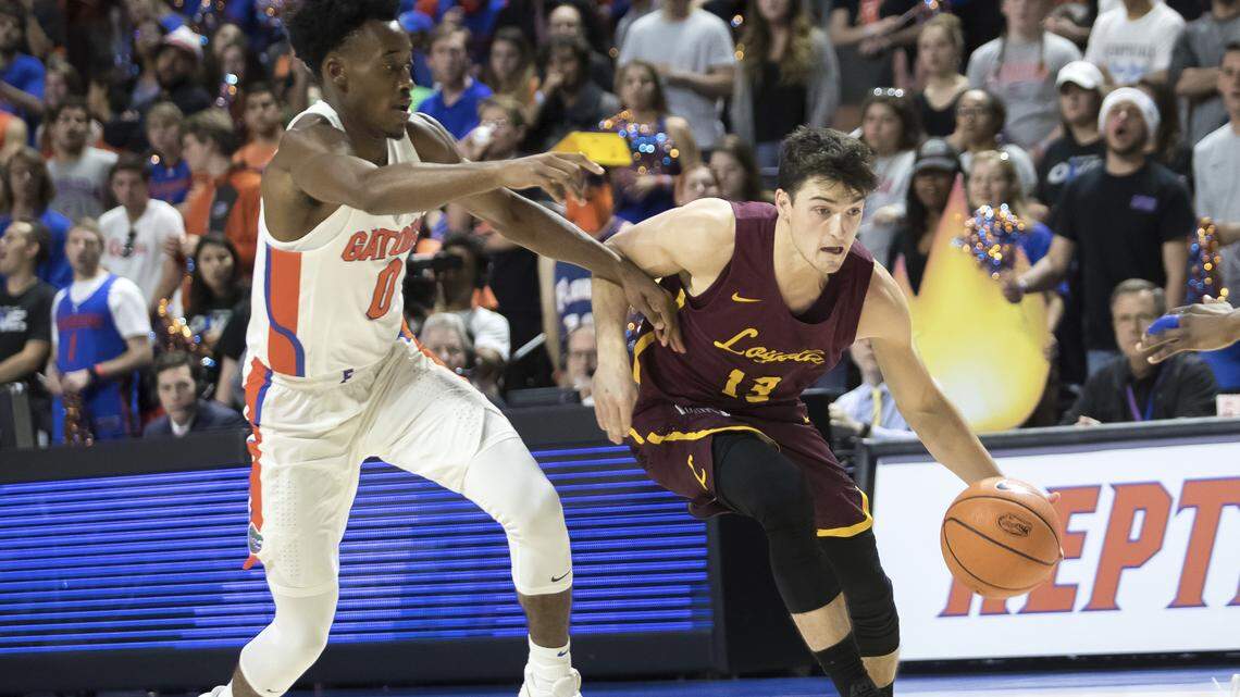 Loyola Chicago guard Clayton Custer (13) drives past Florida guard Mike Okauru (0) during the first half of the Ramblers' 65-59 victory Dec. 6, 2017 in Gainesville, Fla.