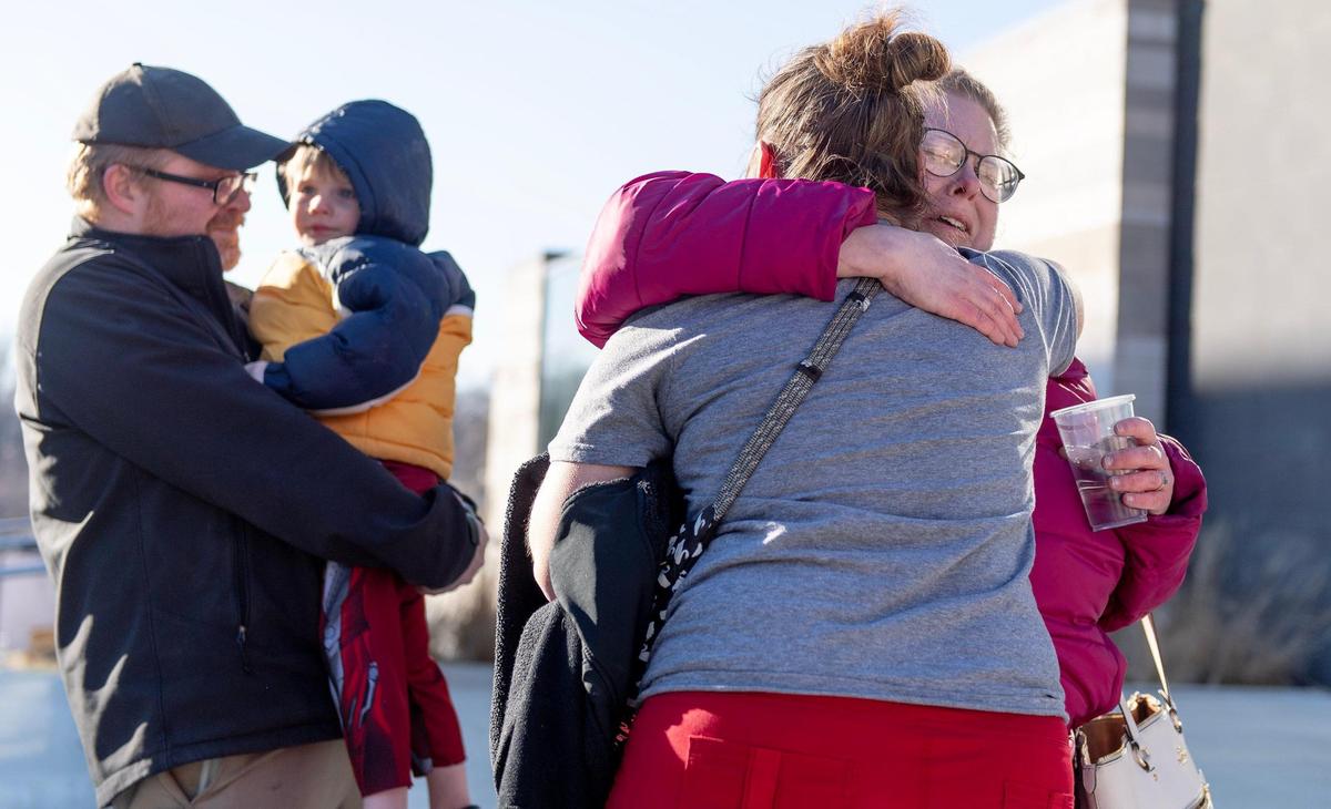 Tiffany Reed hugs Nicole DeHaven, far right, after she and her husband, John DeHaven, turned over their 3-year-old foster child Tuesday afternoon at the Wyandotte County Juvenile Services Center in Kansas City, Kansas.