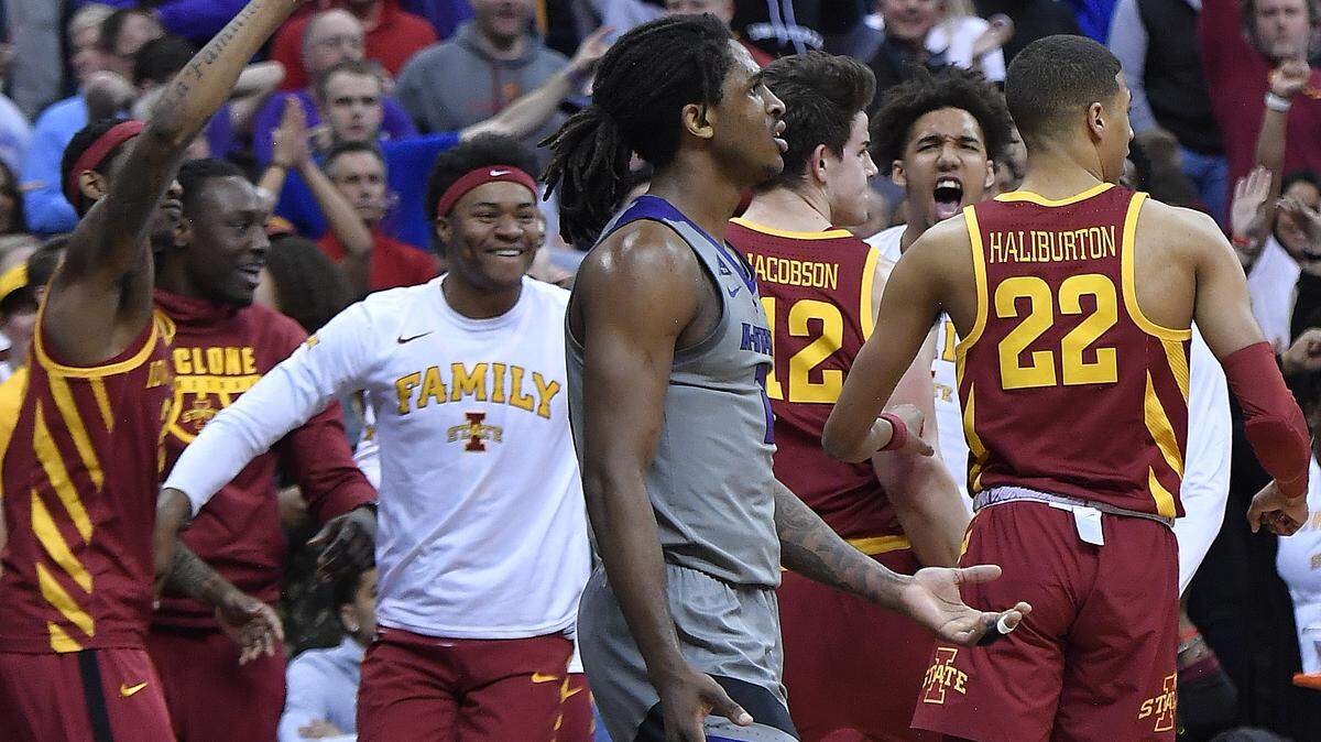As the Iowa State bench celebrates, Kansas State’s Cartier Diarra, middle, walks in disbelief back to the Wildcat bench after ISU’s Marial Shayok hit a game-winning three point shot to give the Cyclones the win Friday night in the Big 12 Tournament.
