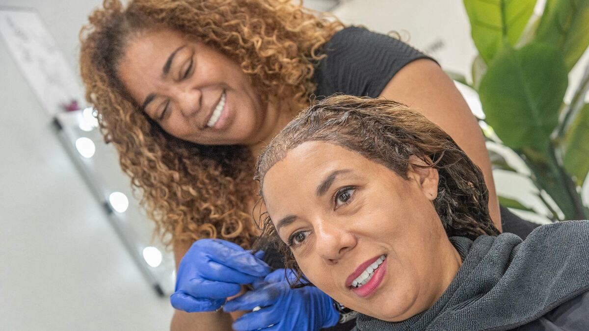 Salon owner Tippi Shorter Rank styles the hair of Vantania Pelzee at Hair Love KC.